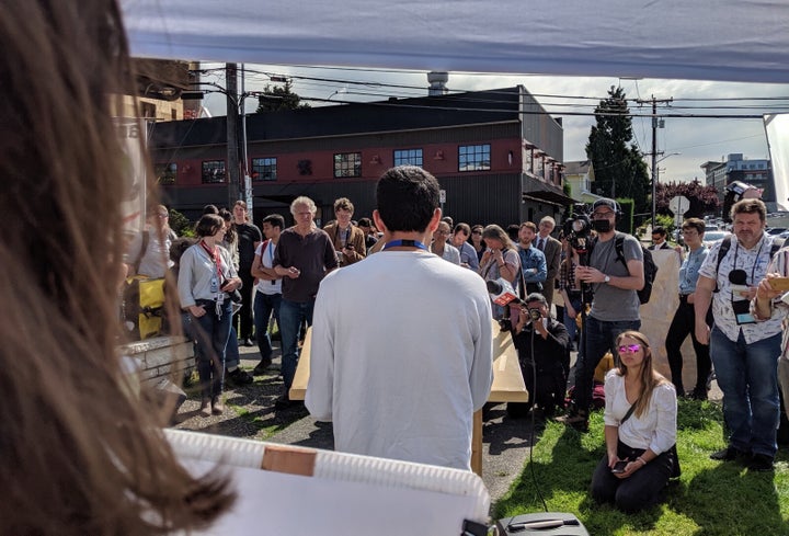 Reporters cover Rajit Iftikhar speaking at an employee-led event calling for greater corporate climate ambition.