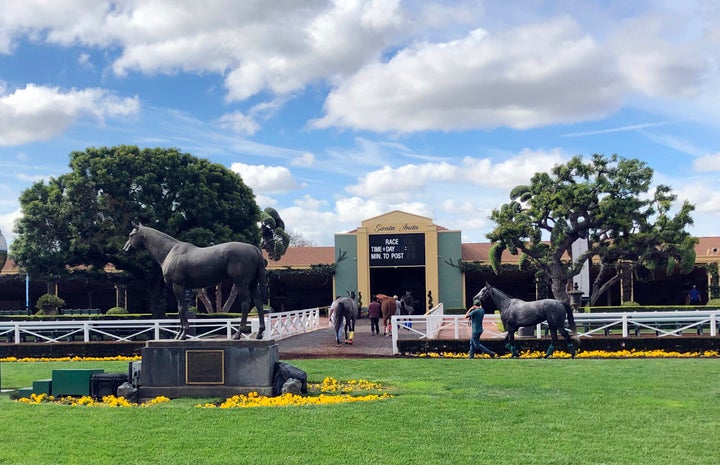 Horses are led to paddocks past the Seabiscuit statue during workouts at Santa Anita Park in Arcadia, California, on March 28