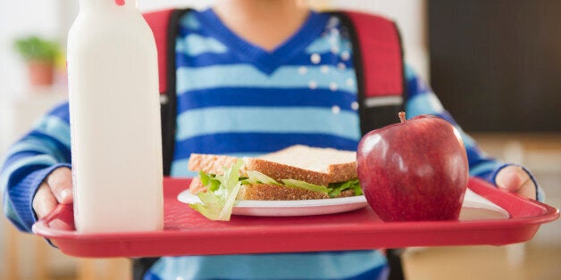 African American school girl holding lunch on a tray