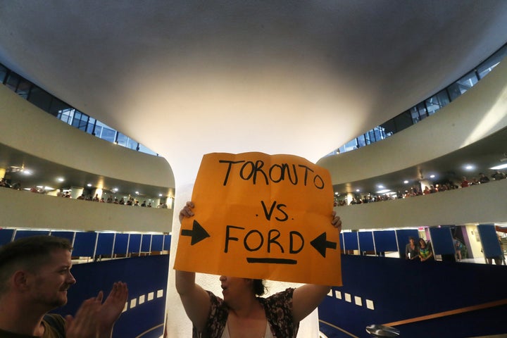 Protesters gather in Toronto city hall July 27, 2018 after an emergency motion pertaining to Premier Doug Ford's plan to cut the size of Toronto City Council down to 25 seats from the 47 seats.