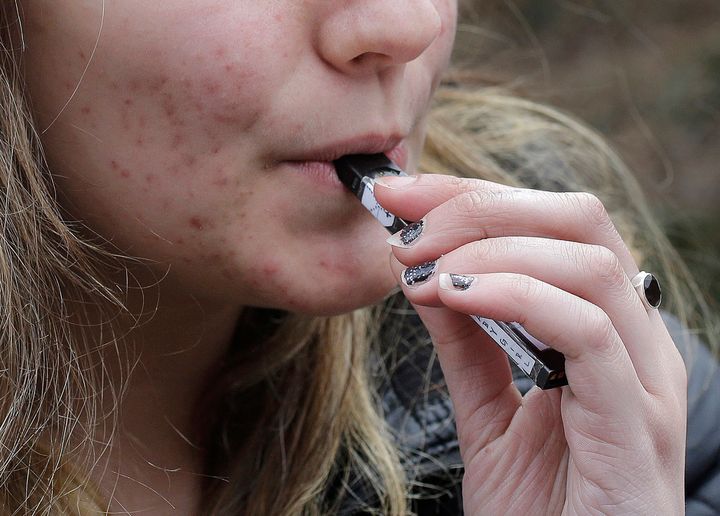 A high school student uses a vaping device near a school campus in Cambridge, Massachusetts. E-cigarettes are the most commonly used tobacco product among youth.