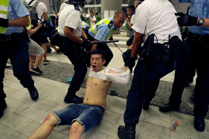 Hong Kong police officers drag away a protester during a rally against proposed amendments to the extradition law at the Legislative Council in Hong Kong during the early hours of Monday, June 10, 2019.