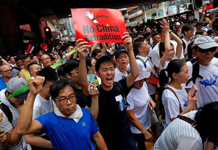 Protesters break through a police line as protesters march against the proposed amendments to an extradition law in Hong Kong Sunday, June 9, 2019. 