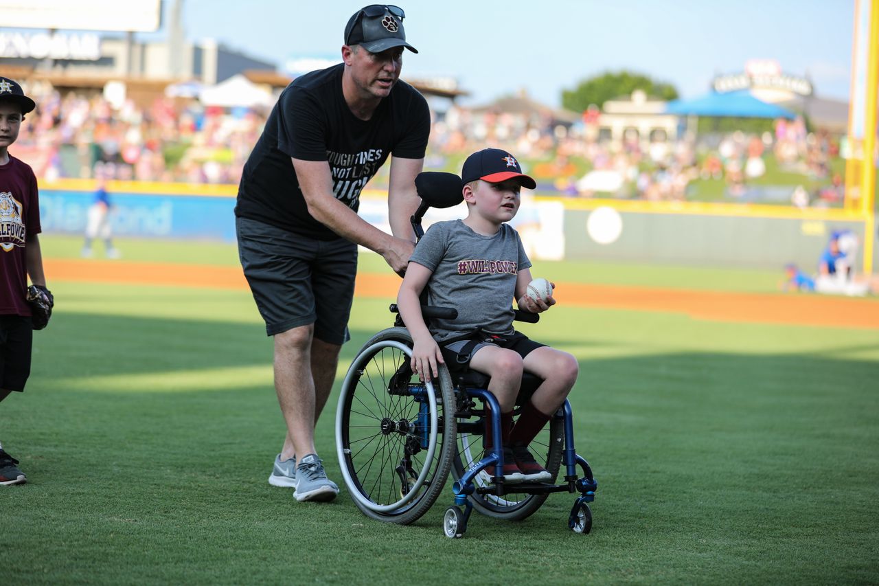Will Allen, 7, threw out the first pitch with his dad by him before a baseball game for the Round Rock Express, the Houston Astros farm club, in May.