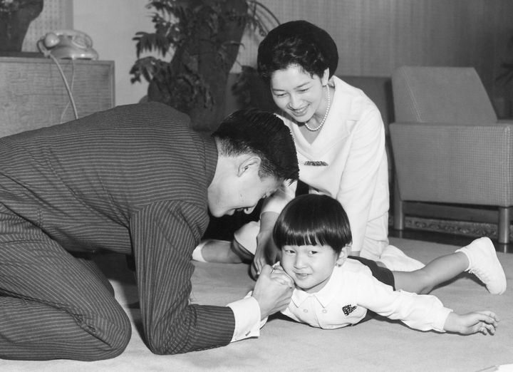 天皇陛下（当時）と腕相撲をされる浩宮さまと見守られる美智子さま＝1964年2月、東京都港区の東宮御所