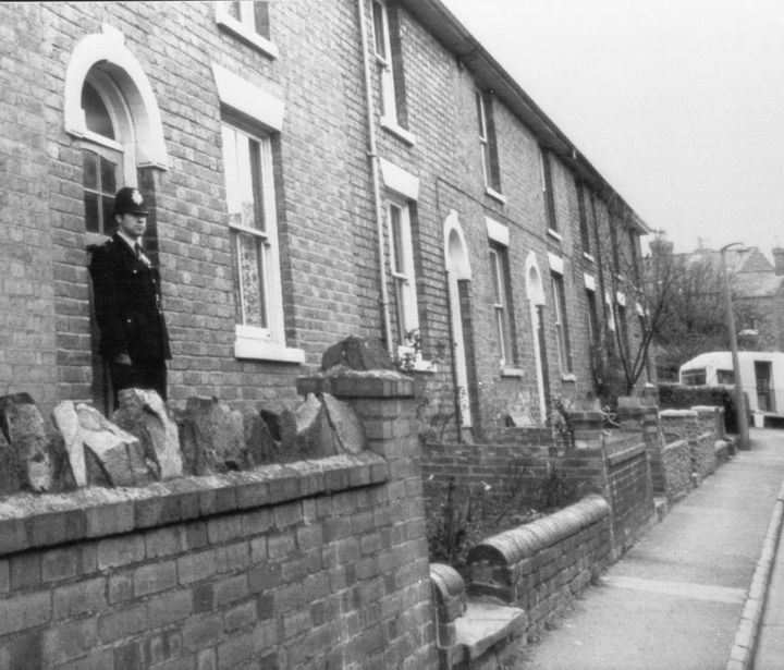 A police officer stands watch at the family home where the children were murdered 