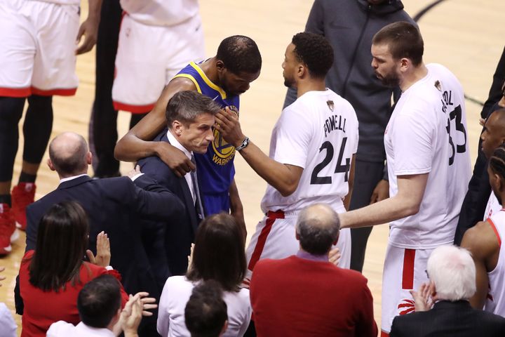 Kevin Durant of the Golden State Warriors is assisted off the court after sustaining an injury in the first half against the Toronto Raptors during Game Five of the 2019 NBA Finals at Scotiabank Arena on June 10, 2019 in Toronto.