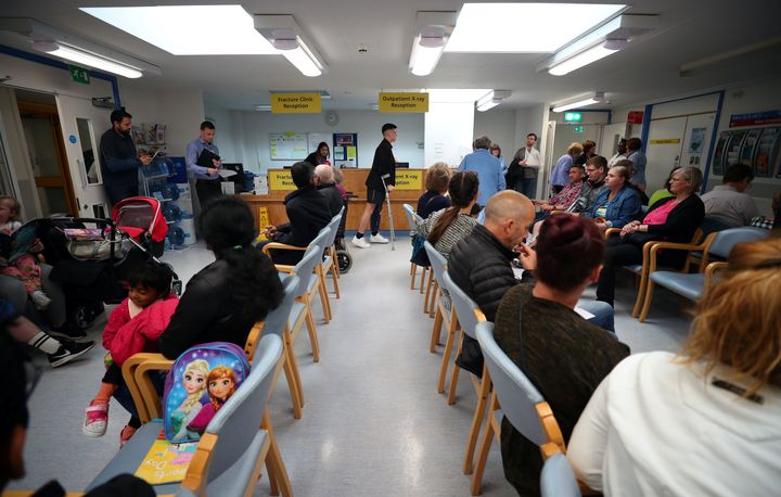 People wait in the waiting room at Milton Keynes University Hospital in Milton Keynes.