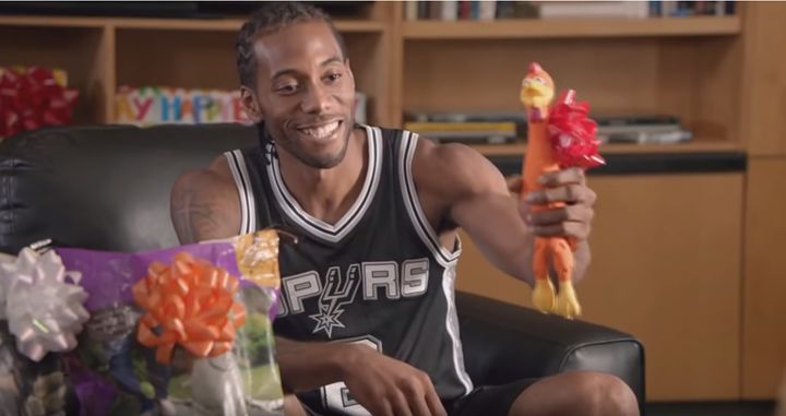 Yes, this truly is a photo of Kawhi Leonard smiling and holding a rubber chicken.