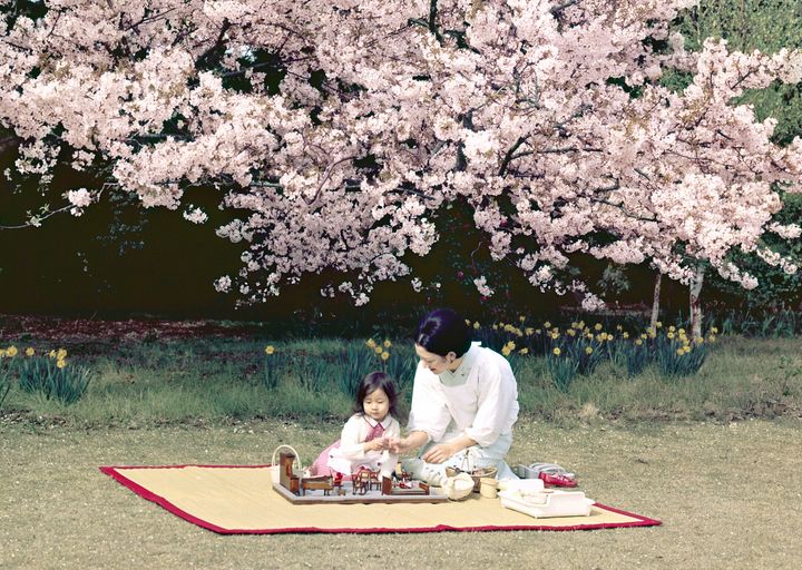 満開の桜の下で、ままごとをされる紀宮さま（黒田清子さん）と皇后さま＝1973年4月、東京都港区の東宮御所（宮内庁提供）