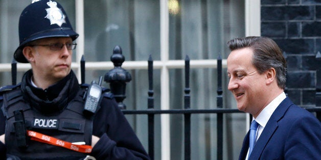 A police officer stands by as Britain's Prime Minister David Cameron leaves 10 Downing Street in London, Thursday, Nov. 20, 2014. David Cameron will attend a Liaison Committee Thursday, the meeting focuses on the Governance of the UK in the light of the Scottish Referendum. (AP Photo/Kirsty Wigglesworth)