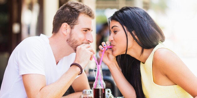 Hispanic couple drinking soda at cafe