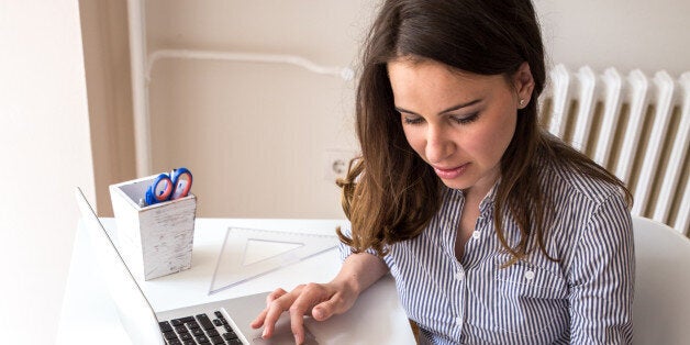 Female architect working at home.She looking at blueprint.