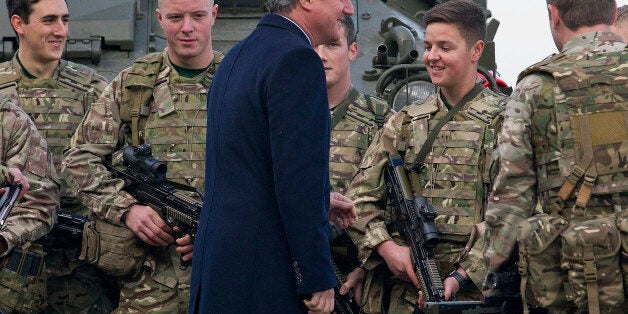 British Prime Minister David Cameron talks with soldiers from the Royal Welsh Infantry as they stand in front of a Lockheed Martin Warrior Infantry Fighting Vehicle, during his visit to Royal Air Force station RAF Northolt, in west London, before presenting his Government's Strategic Defence and Security Review (SDSR) to Parliament