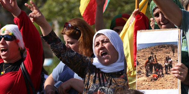 In this Sept. 15, 2014, photo, Kurdish citizens who live in Lebanon shout slogans and hold a photograph during a demonstration against militants who refer to themselves as the Islamic State, in front of the UN building, in downtown Beirut, Lebanon. Osama bin Laden is dead and al-Qaida dispersed, yet the horrors keep coming. Journalists beheaded on camera. School girls abducted by gunmen in the night. Families fleeing their homes in fear they might be executed because of their religion. The news