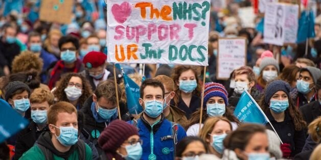 Junior doctors and their supporters stage sit-down protest outside Downing Street, in Westminster, London, during a "masked march" protest over pay and conditions, the third time they have taken to the streets in protest at the Government's proposals, which it says aims to improve care over weekends.