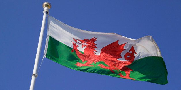 Close up of welsh flag against blue sky, low angle view