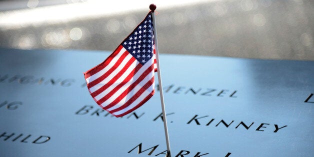 NEW YORK, NY - SEPTEMBER 11: A flag adorns the 9/11 Memorial on the twelfth anniversary of the terrorist attacks on lower Manhattan at the World Trade Center site on September 11, 2013 in New York City. The nation is commemorating the anniversary of the 2001 attacks which resulted in the deaths of nearly 3,000 people after two hijacked planes crashed into the World Trade Center, one into the Pentagon in Arlington, Virginia and one crash landed in Shanksville, Pennsylvania. Following the attacks