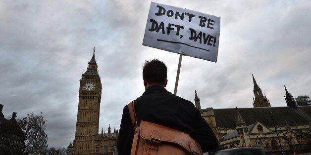 A lone protester opposed to British military action in Syria holds a placard reading 'Don't be daft, Dave!' outside the Houses of Parliament