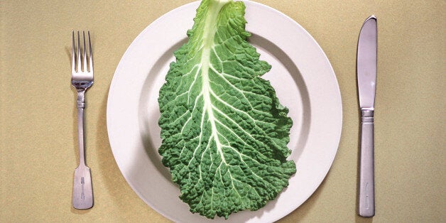 Single leaf of raw kale on ceramic dinner plate