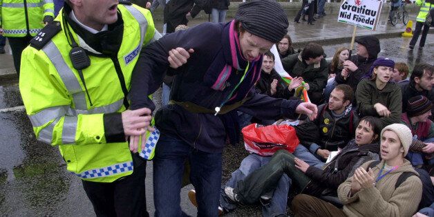 Matthew Walsh, 21, a student studying fine art at Pembroke College, Oxford, is pulled away by a police officer during a sit-in by some students on Waterloo Bridge in central London. *Thousands of students from across the UK descended upon London to begin a march through the capital to protest against the idea of top-up fees for students.
