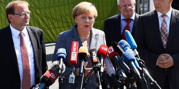 German Chancellor Angela Merkel (2nd L) makes a statement flanked by Heidenau's mayor Juergen Opitz (L), Red Cross president Rudolf Seiters (2nd R) and Saxony's State Premier Stanislaw Tillich (R) after a visit to a shelter for asylum-seekers in Heidenau, eastern Germany