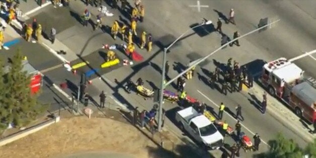 First responders gather on a nearby street corner as victims are treated outside a Southern California social services center in San Bernardino, Calif., where authorities said multiple people were shot Wednesday, Dec. 2, 2015. (KTTV via AP)