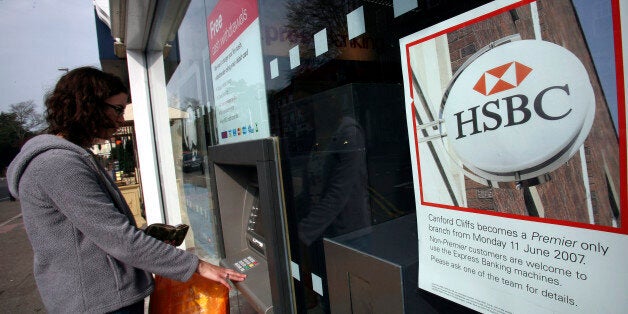 POOLE, UNITED KINGDOM - APRIL 14: A woman uses a cash machine outside the branch of HSBC in Canford Cliff on April 14 2007 in Poole, Dorset. The area has some of the most expensive and exclusive property in the UK. A local HSBC branch recently announced that only ?premier? customers would be able ti use its services, with customers needing savings of at least GBP50,000 and a GBP200,000 mortgage or a GBP100,000 mortgage plus a salary of GBP75,000 to obtain cashier assistance. (Photo by Matt Card