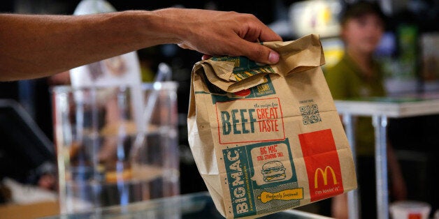 A customer takes a McDonald's Corp. bag of food inside a McDonald's restaurant in Manchester, U.K., on Monday, Aug. 10, 2015. McDonald's Chief Executive Officer Steve Easterbrook predicted a return to growth for the burger chain in the second half of the year, giving investors cause for optimism after another quarter of slumping sales. Photographer: Paul Thomas/Bloomberg via Getty Images