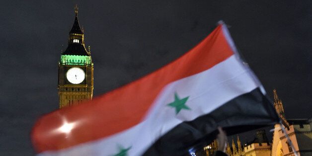 LONDON, ENGLAND - DECEMBER 01: Protesters hold up a Syrian flag as they take part in a Stop The War Coalition emergency protest on December 1, 2015 in London, England. The emergency protest, which will march past The Conservative and Labour party headquarters, has been organised ahead of tomorrows vote in Parliament on whether the United Kingdom will commence bombing operations over Syria. (Photo by Ben Pruchnie/Getty Images)