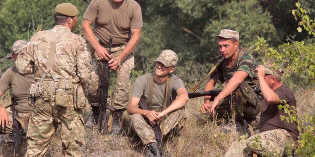 British servicemen, left, instruct Ukrainian soldiers during training exercises on the military base outside Zhitomir, Ukraine, Tuesday, Aug. 11, 2015. (AP Photo/Efrem lukatsky)