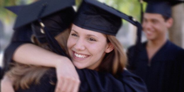 Young female graduates hugging