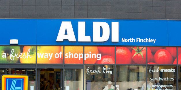 A woman using a motorized cart, sits outside the entrance to an Aldi supermarket store in London, U.K., on Monday, June 29, 2015. The growth of Aldi and fellow German-owned discounter Lidl has changed the British grocery landscape over the last five years. Photographer: Jason Alden/Bloomberg via Getty Images