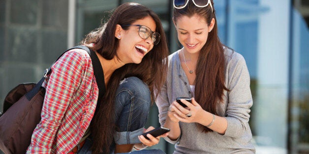 Two female friends using mobile phones