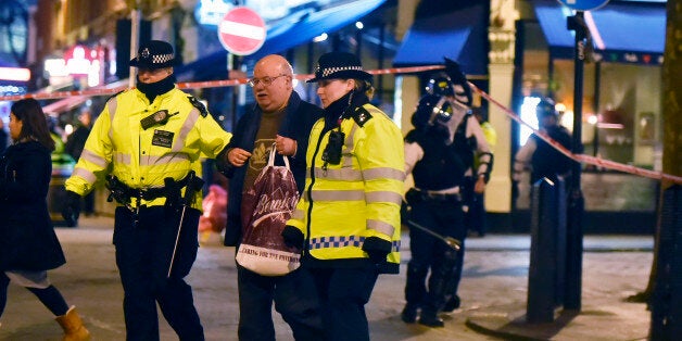 Police lead a man to safety from a branch of Bella Italia in Leicester Square, London, after a man took a woman hostage with a knife in the restaurant.