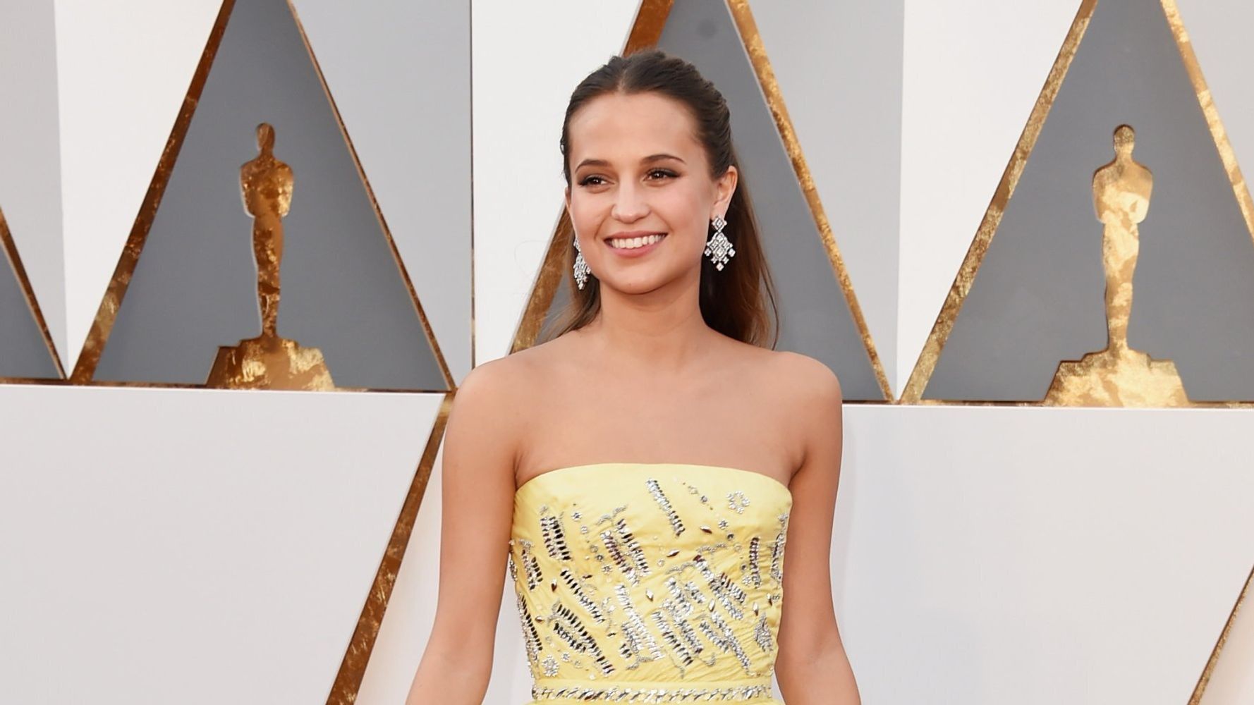 Alicia Vikander on stage at the 2016 Oscars wearing Louis Vuitton, Louis Vuitton  LV Trainer Grey Sneaker
