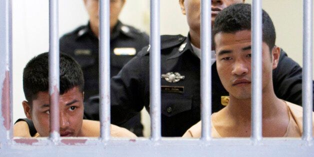 Myanmar migrants Win Zaw Htun, right, and Zaw Lin, left, both 22, are escorted by officials after their guilty verdict at court in Koh Samui, Thailand, Thursday, Dec. 24, 2015. A Thai court on Thursday sentenced the two Myanmar migrants to death for killing British backpackers David Miller, 24, and Hannah Witheridge, 23, on the resort island of Koh Tao last year, a crime that focused global attention on tourist safety and police conduct in the country. (AP Photo/Wason Wanichakorn)