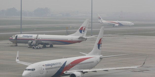 A fleet of Malaysia Airline planes are shrouded in haze at the Kuala Lumpur International Airport in Sepang, Malaysia on Sunday, Sept. 27, 2015. Wildfires caused by illegal land clearing in Indonesia's Sumatra and Borneo islands often spread choking haze to neighboring countries such as Malaysia and Singapore. (AP Photo/Joshua Paul)