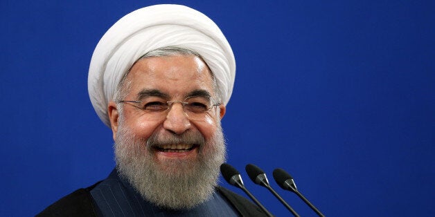 FILE - In this Aug. 29, 2015 file photo, Iran's President Hassan Rouhani smiles during his press conference in Tehran, Iran. Rouhani said Tuesday, Sept. 8, 2015 that his country is ready to hold talks with the United States and Saudi Arabia on ways to resolve the Syrian civil war, providing such negotiations can secure peace and democracy in conflict-torn Syria. Rouhani's remarks came during a press conference on Tuesday with visiting Austrian counterpart Heinz Fischer. (AP Photo/Ebrahim Noroozi