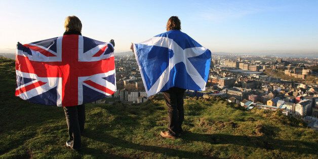 Scottish and English flags held up over Edinburgh, Scotland
