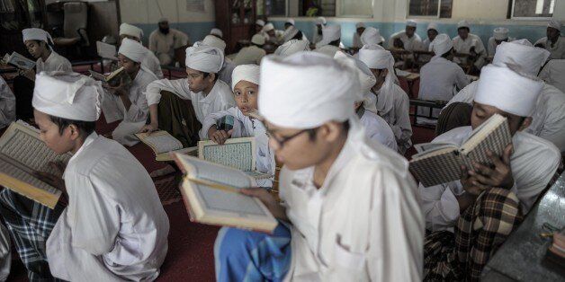 A Malaysian religious student (C) looks on as others read and memorise the Koran at a seminary during the Muslim holy fasting month of Ramadan in Hulu Langat, near Kuala Lumpur on June 22, 2015. Islam's holy month of Ramadan is celebrated by Muslims worldwide marked by fasting, abstaining from foods, sex and smoking from dawn to dusk for soul cleansing and strengthening the spiritual bond between them and the Almighty. AFP PHOTO / MOHD RASFAN (Photo credit should read MOHD RASFAN/AFP/Gett