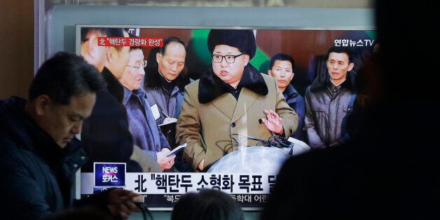 People watch a TV news program showing North Korean leader Kim Jong Un with superimposed letters that read: