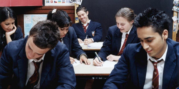 Teenage schoolchildren (14-16) writing in classroom