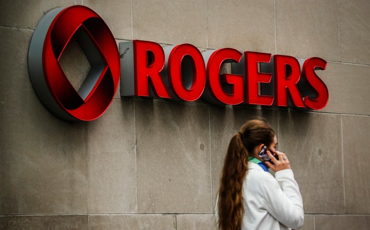 A woman speaks on her cell phone in front of a Rogers Communications sign before the company's annual general meeting in Toronto, April 22, 2014.