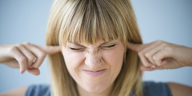 Woman blocking ears with fingers