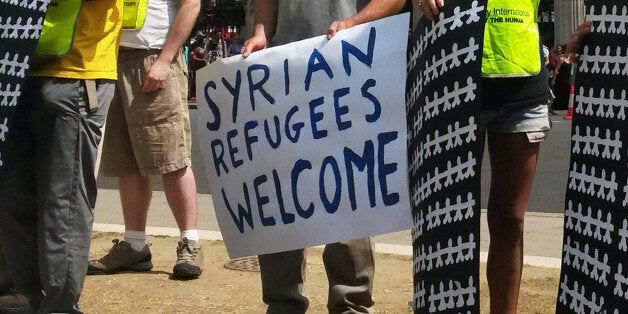 A person holds a sign as Amnesty International members protest the number of Syrian refugees taken in by the UK, in Parliament Square, London.