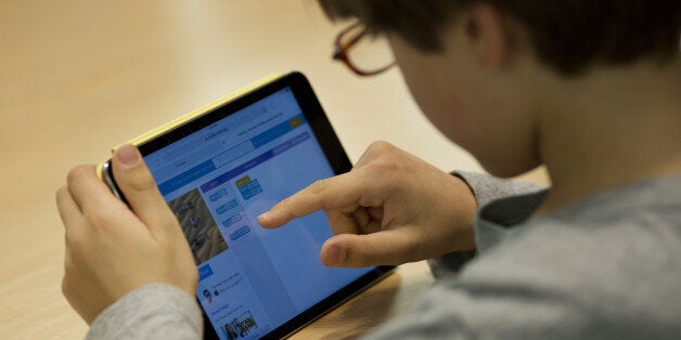 A kid learns how to build a video game using code on an Apple Inc. iPad Mini during the Hour of Code workshop at an Apple store in New York, U.S., on Thursday, Dec. 10, 2015. Hour of Code, a free one-hour introduction to the basics of computer programming, is a special event for kids ages six and up hosted by Apple Inc. in conjunction with Computer Science Education Week. Photographer: Victor J. Blue/Bloomberg via Getty Images