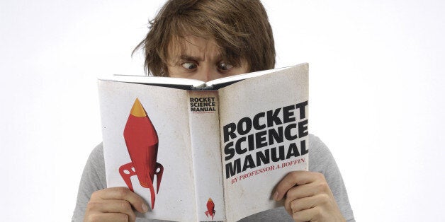 A man looking confused whilst reading a book on rocket science, during a studio shoot for Guitarist Magazine, June 10, 2010. (Photo by Jesse Wild/Guitarist Magazine via Getty Images)