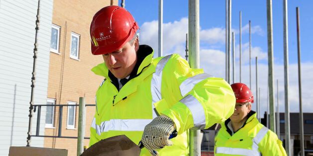 Prime Minister David Cameron tries his hand at brick laying during a visit to the Barratt Homes Evolve development in Grays, Essex.