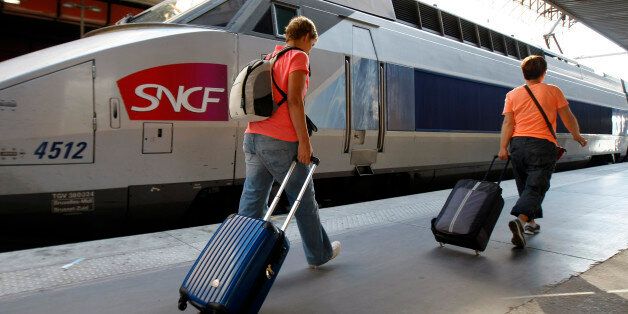 People walk on a platform to take a TGV (High Speed Train) at the Gare St-Charles station in Marseille, southern France , Thursday, June 12, 2014